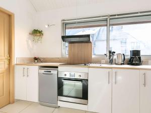 een keuken met witte kasten en een fornuis met oven bij Studio Bourisp, 1 pièce, 4 personnes - FR-1-296-495 in Bourisp