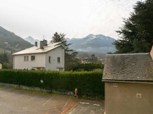 een wit huis met bergen op de achtergrond bij Studio Bourisp, 1 pièce, 4 personnes - FR-1-296-495 in Bourisp