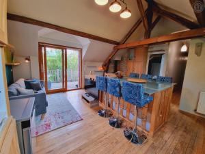 - une cuisine avec un bar et des chaises bleues dans la chambre dans l'établissement Appartement tout équipé dans un cadre naturel, proche du Parc Avesnois et commodités, jusqu'à 5 pers. - FR-1-510-189, à Orsinval