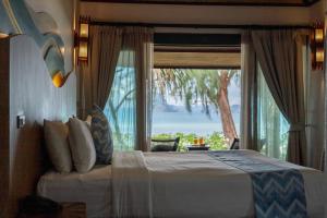 a bedroom with a bed and a large window at Tup Kaek Sunset Beach Resort-SHA Plus in Tab Kaek Beach