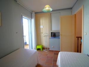 una camera con due letti e una cucina con finestra di Casa Llançà, 3 dormitorios, 6 personas - ES-228-176 a Llança