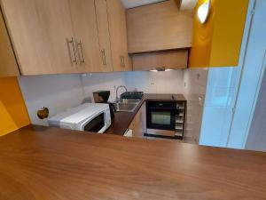 eine kleine Küche mit einer Spüle und einer Mikrowelle in der Unterkunft Studio Marseillan-Plage, 1 pièce, 2 personnes - FR-1-326-804 in Marseillan