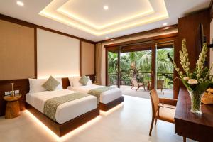 a hotel room with two beds and a balcony at Svarga Bebek Villas in Ubud