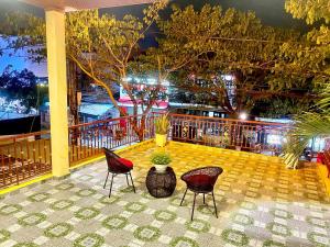 un patio con 2 sillas y una mesa con una planta en King Kong Homestay, en Hoi An