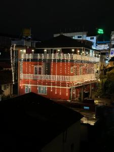 un edificio con luces de Navidad encendidas por la noche en Coorg Cu’s Homestay, en Madikeri