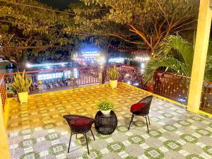 un patio avec deux chaises et une table avec des lumières dans l'établissement King Kong Homestay Hoi An, à Hội An