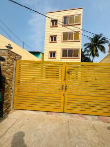 a yellow gate in front of a house at Hotel Golden Homes Inn Puri in Puri
