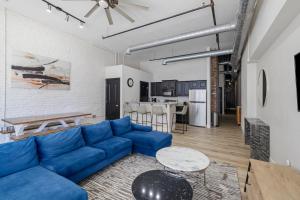 a living room with a blue couch and a kitchen at Art District Loft - 4BD/2BA Downtown SGF in Springfield