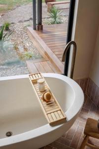 a bath tub with a tray with a donut on it at Rest Private Escape at BoxGrove in Bathurst