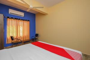 - une chambre avec un lit, deux chaises et une fenêtre dans l'établissement Collection O 19289 The Olive Grand, à Mysore