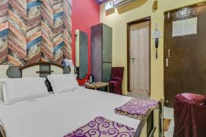 KāyankulamにあるOYO HOTEL RAGAのベッドルーム1室(ベッド1台、椅子付)