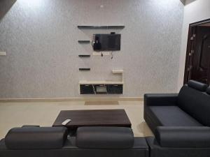 a living room with a couch and a tv at Galeela Plaza in Tāmarakulam