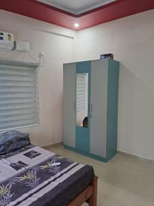1 dormitorio con 1 cama con armario azul y blanco en Galeela Plaza, en Tāmarakulam