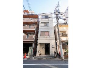 両国駅前 في طوكيو: عمارة سكنية فيها عمود تلفون بجانب شارع