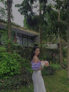 una joven está sosteniendo un ramo de flores en Bách Thanh Villa C15 - FLAMINGO ĐẠI LẢI, en Phúc Yên