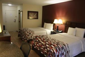a hotel room with two beds and a table at Red Roof Inn Gurnee - Waukegan in Waukegan