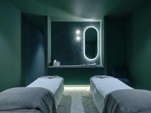a green room with two beds and a mirror at Ardo in Townsville