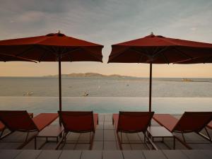 a group of chairs and umbrellas next to the water at Ardo in Townsville