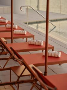 a row ofoccupied chairs with towels on them next to a swimming pool at Ardo in Townsville