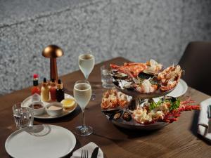 a table with two plates of food and glasses of wine at Ardo in Townsville