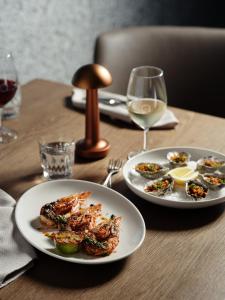 a table with two plates of food and a glass of wine at Ardo in Townsville