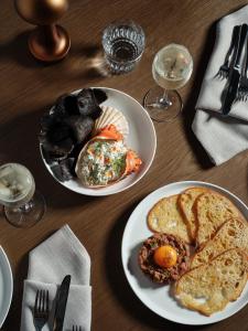 a wooden table with two plates of breakfast foods at Ardo in Townsville