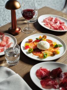 a table with plates of food and a glass of wine at Ardo in Townsville