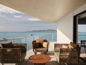 a balcony with chairs and a view of the ocean at Ardo in Townsville