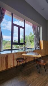 a room with a table and chairs and a large window at THẢO NGUYÊN VILLA BẢO LỘC in B'su M'rac