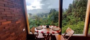 tavolo e sedie in una stanza con una grande finestra di Cabaña Rodamonte - Neusa a Cogua