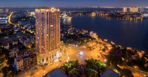 uma vista aérea de uma cidade à noite com um edifício alto em QMP - D'Eldorado Tân Hoàng Minh Tây Hồ em Hanói