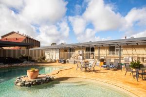 a house with a swimming pool and a patio at New England Motor Lodge in Glen Innes