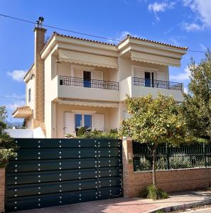 a house with a black fence in front of it at Aegean Sea Home in Nea Makri