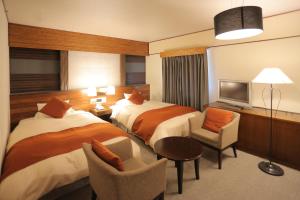 a hotel room with two beds and a television at Kurashiki Kokusai Hotel in Kurashiki