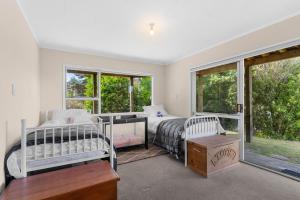 um quarto com 2 camas e uma janela em Sun and Coast - Mangawhai Heads Holiday Home em Mangawhai