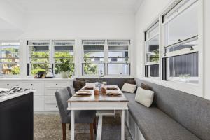 a dining room with a table and some windows at Bridget House in Coffs Harbour
