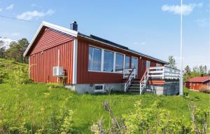 a red house on top of a grassy hill at Amazing Home In Leines With House Sea View in Leines