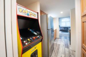 a pinball machine in a room with a refrigerator at The BEST Tiny Home with 2 Queens in San Luis Obispo