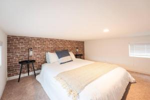 a bedroom with a bed and a brick wall at The BEST Tiny Home with 2 Queens in San Luis Obispo