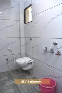 La salle de bains blanche est pourvue d'une douche et de toilettes. dans l'établissement HOTEL SAI VISHVA KARMA, à Shirdi
