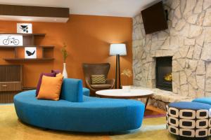 a living room with a blue couch and a stone fireplace at Fairfield Inn Manhattan, Kansas in Manhattan