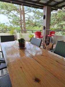 Haven Haus with Mountain View في باغيو: طاولة وكراسي خشبية على الفناء