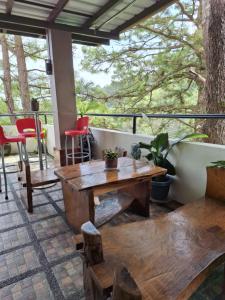 um alpendre com uma mesa e cadeiras de madeira em Haven Haus with Mountain View em Baguio