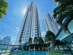 un grand bâtiment blanc avec des palmiers devant lui dans l'établissement D'Rapport Residences by Manhattan Plus, à Kuala Lumpur