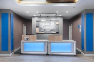 a lobby with a reception desk with blue lights at Holiday Inn Express & Suites Florence I-95 & I-20 Civic Ctr, an IHG Hotel in Florence