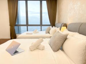Cette chambre comprend un lit blanc avec un ordinateur portable. dans l'établissement D'Rapport Residences by Manhattan Plus, à Kuala Lumpur