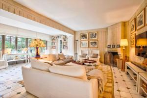 uma sala de estar com mobiliário branco e uma lareira em L'Oasis - Deauville Centre - Garden em Deauville