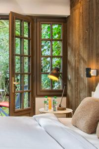 um quarto com uma cama e uma mesa com um candeeiro em L'Oasis - Deauville Centre - Garden em Deauville
