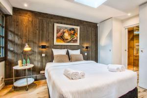 um quarto com uma grande cama branca e paredes de madeira em L'Oasis - Deauville Centre - Garden em Deauville