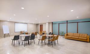 a conference room with tables and chairs and a couch at Treebo Trend FlxHo Trio - Medanta Medicity Gurgaon in Gurgaon